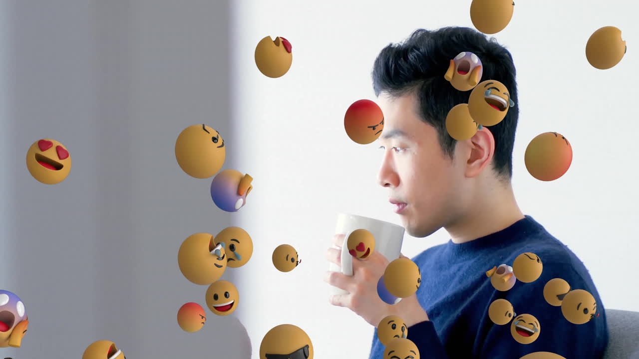 man sipping mug indoors, showing floating emoji spheres for digital marketing and social media