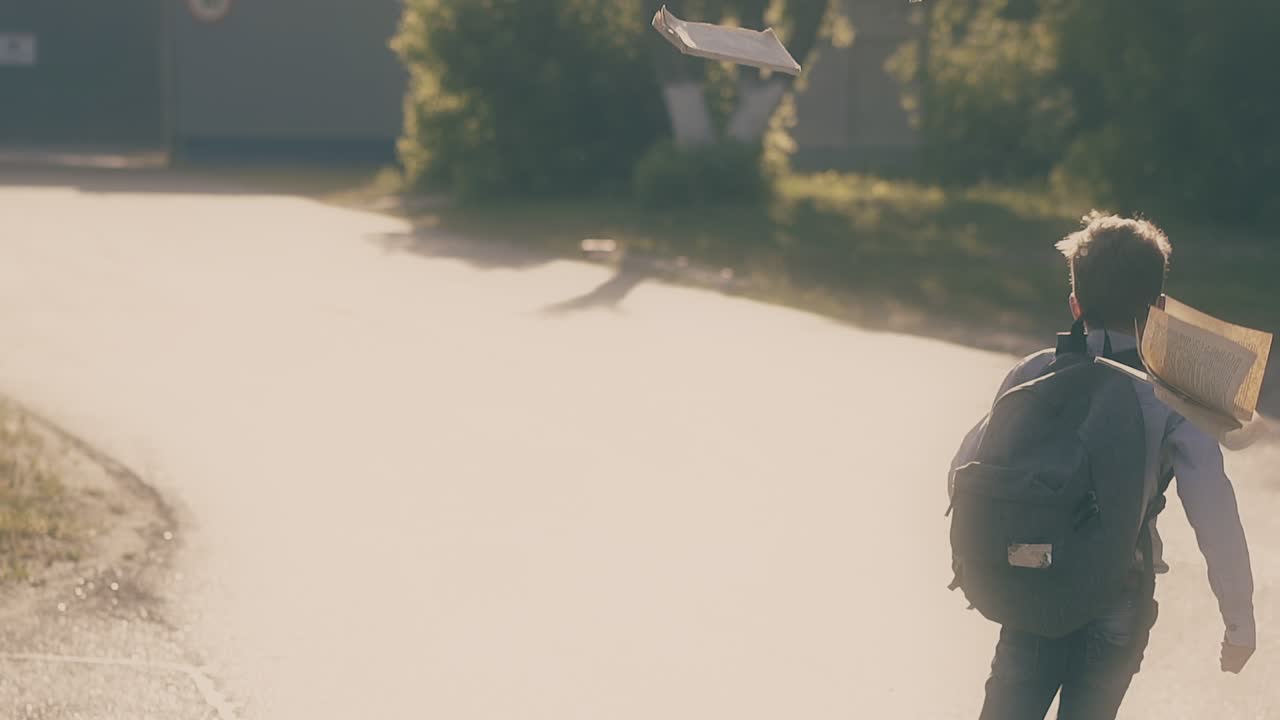 소년은 도로에 뛰어들어 시험을 치른 후 서류를 던진다.