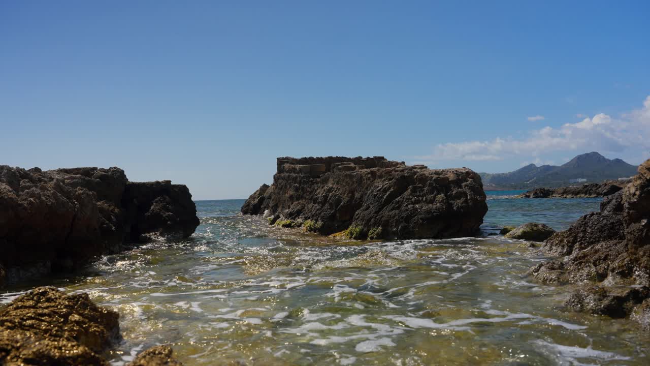Shallow and clear Water at rocky coast line in slowmotion