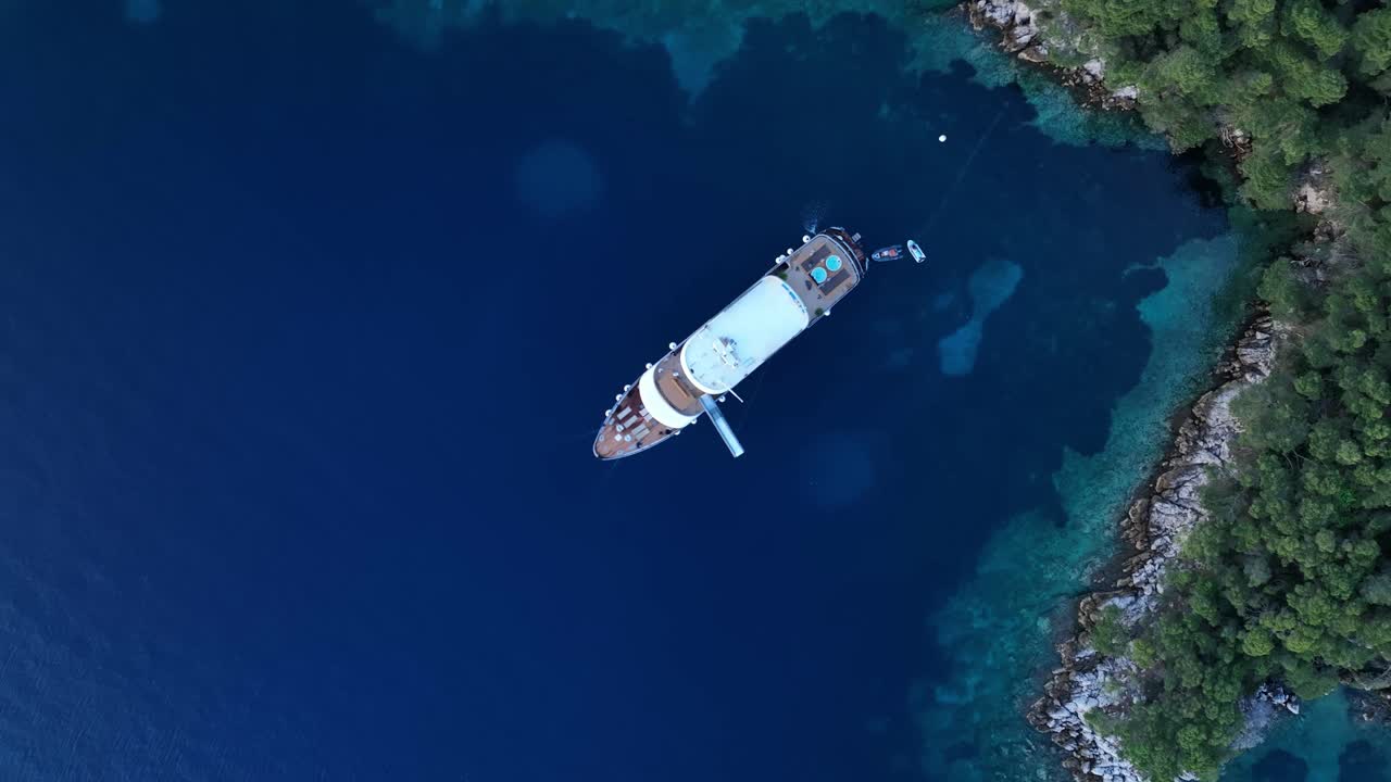Aerial: yacht docked on the Mediterranean Sea during the day in the Kornati Bay, Dalmatia, Croatia, top down drone shot