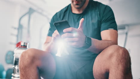 hombre usando teléfono inteligente en el gimnasio