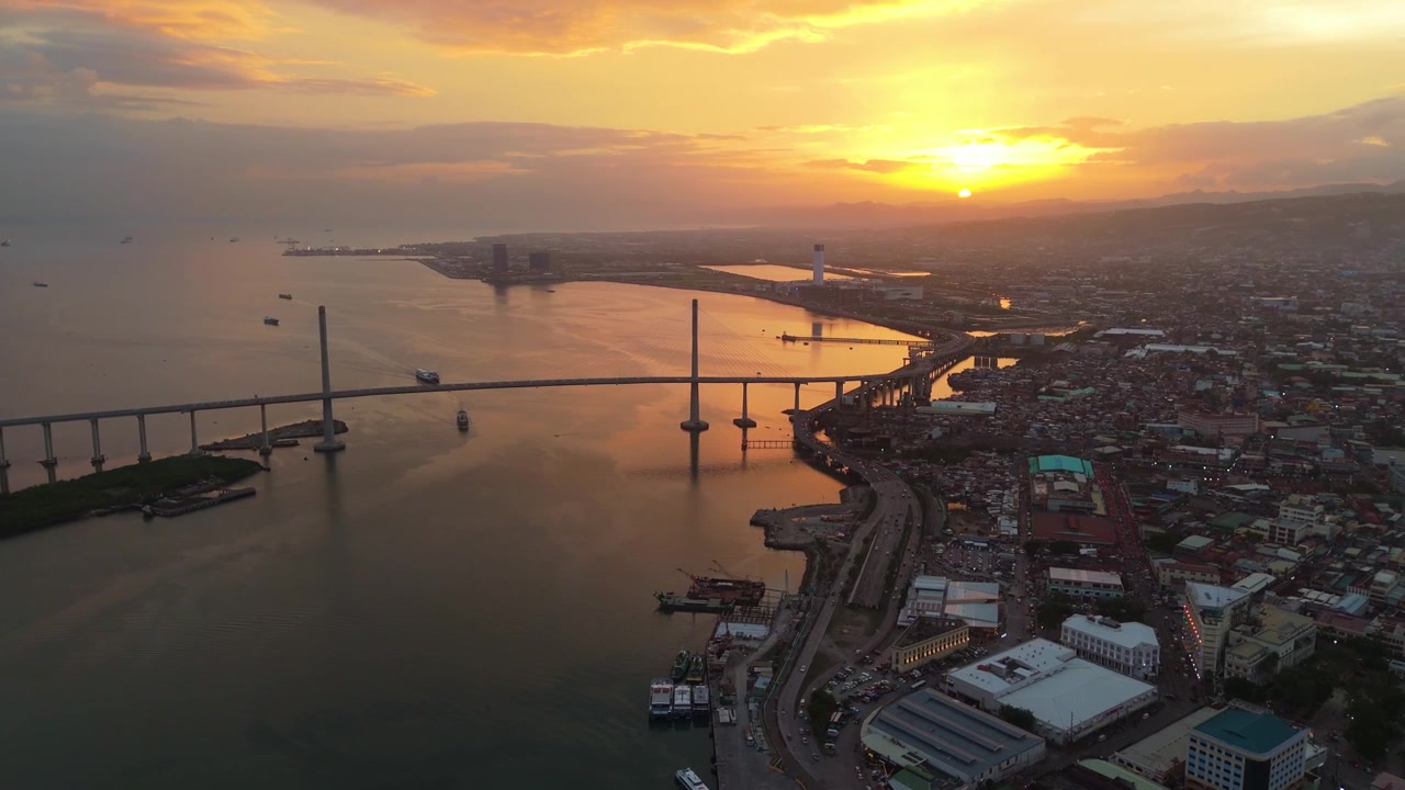 Vista aerea al tramonto dello skyline della città di Cebu ripresa da drone, con il ponte CCLEX.