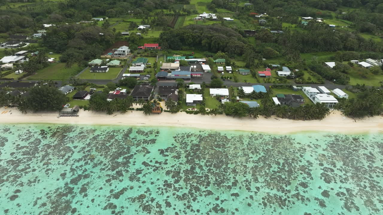 Supermercato e stazione di servizio Wigmore's vicino a una spiaggia tropicale a Rarotonga, veduta aerea.