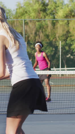 video de la espalda de una jugadora de tenis caucásica entrenando con una amiga