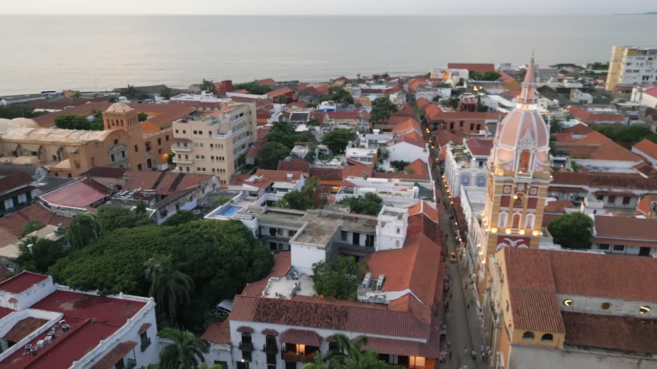 Cidade murada de Cartagena ao pôr do sol, com a cúpula da catedral iluminada à noite, vista aérea da paisagem urbana caribenha da Colômbia.