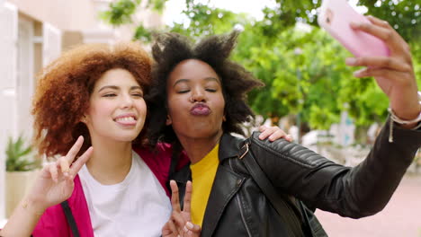 amigas juguetonas tomando selfies con un teléfono