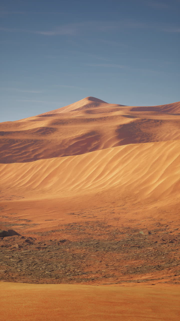 Dune di sabbia rosse e aride sotto un cielo sereno