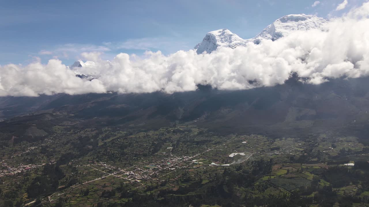 toma panorámica con drones del pico nevado de huascarán con nubes junto a un valle verde en la ciudad de yungay en perú