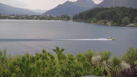 jet boat driving fast on the lake from left to right wide shot in queenstown