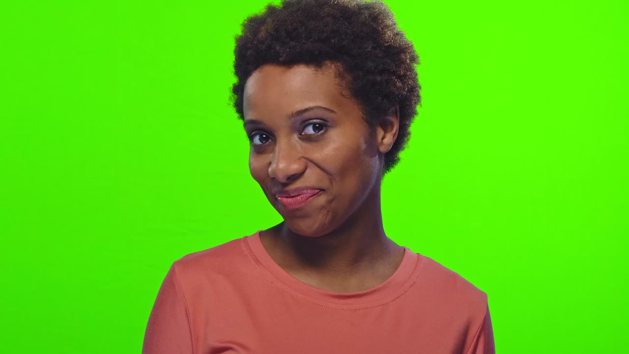 Funny young African American woman with glad expression, blinks eye, flirts