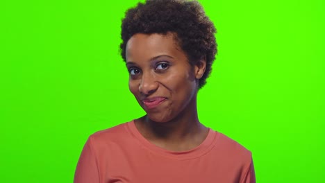 funny young african american woman with glad expression, blinks eye, flirts