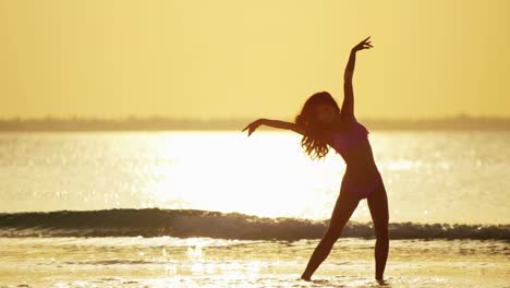 sunrise with barefoot ethnic girl dancing on beach