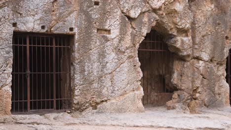 cave entrance with barred gate in rocky terrain