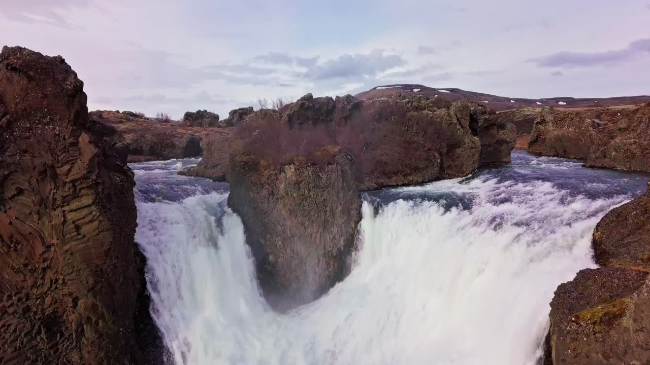 cascadas gemelas sobrevoladoras que fluyen alrededor de terrenos rocosos en islandia
