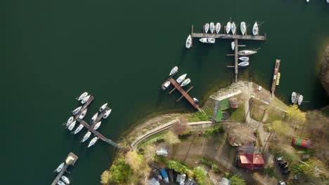 aerial top down view of many recreational boats docked at a lake pier at sunset