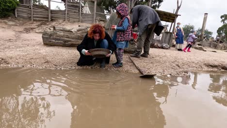 people panning for gold in muddy water