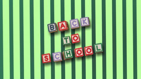 Back-to-school-on-blocks-against-rotating-green-striped-background