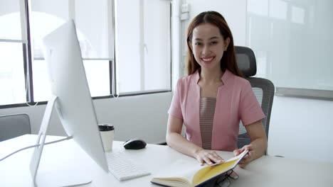 smiling businesswoman working at her desk in a modern office