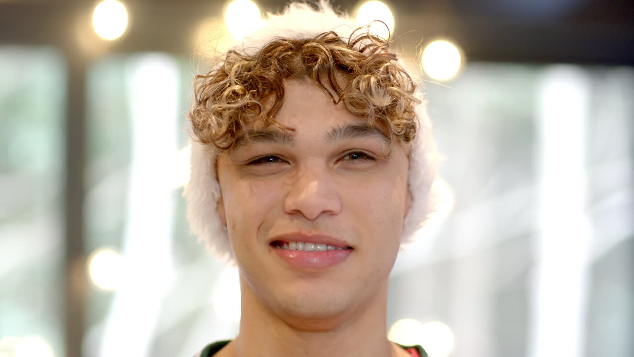 Asian man wearing Santa hat smiling joyfully at home during Christmas