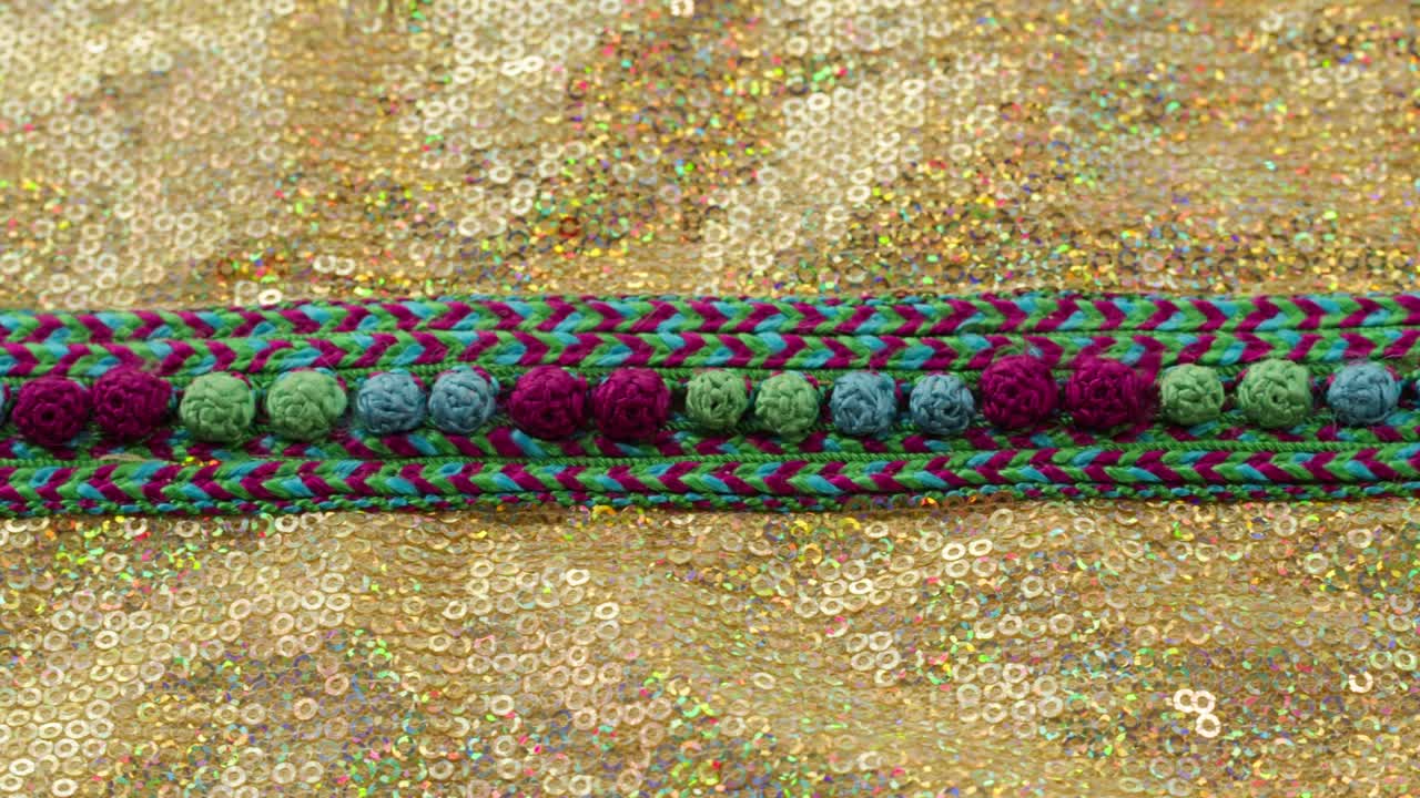 patrón de color tejido en tela brillante dorada con pañuelos de primer plano. confección de ropa festiva. fondo brillante dorado. concepto de coser vestido de año nuevo