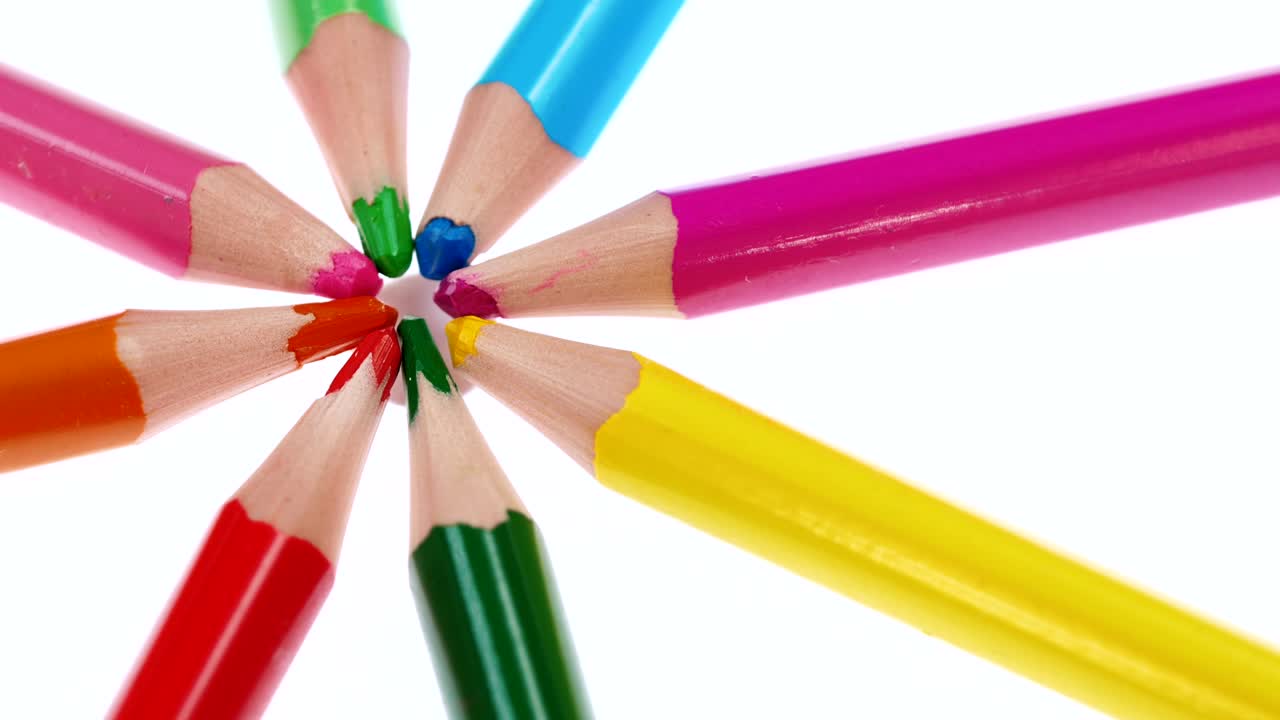 los lápices multicolores de los niños giran sobre un fondo blanco.