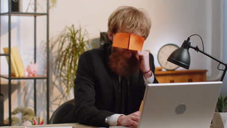 inefficient tired lazy business man working sleeping on laptop computer with eyes stickers on face
