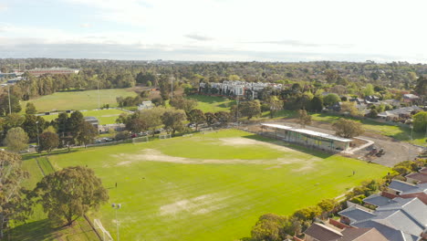 aerial perspective smoothly pushing forward, unveiling parkland area and a playground