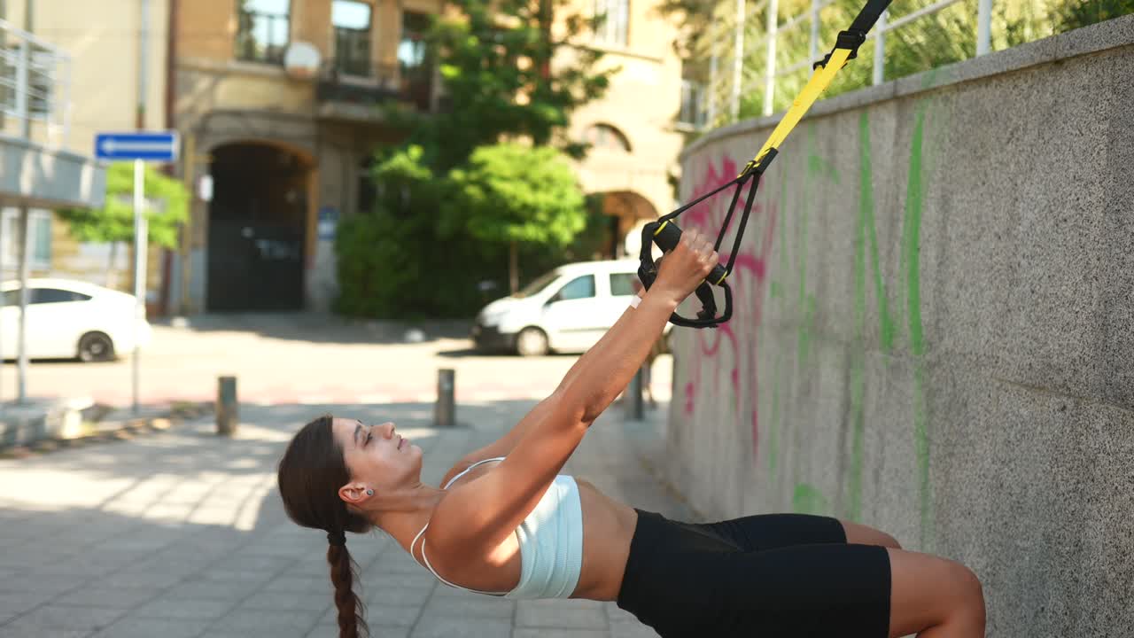 mujer trabajando con equipo de entrenamiento de suspensión afuera