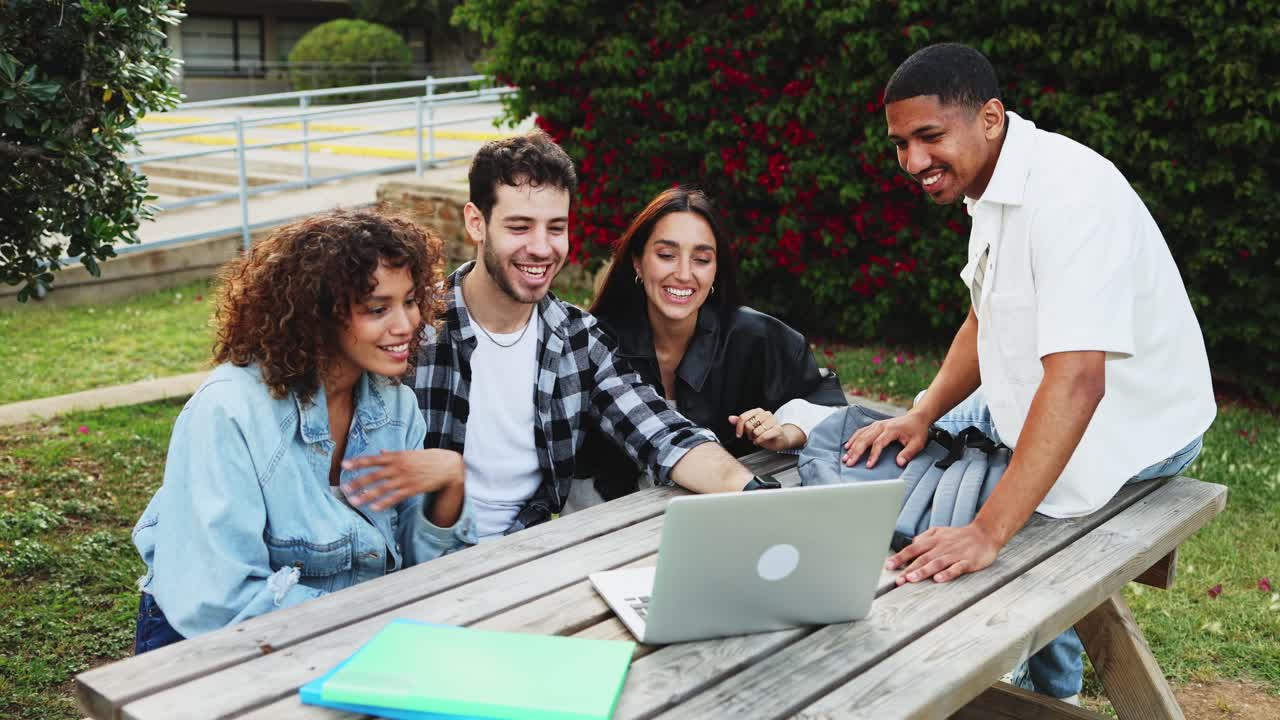 Jóvenes amigos felices saludando a un portátil durante una videollamada al aire libre