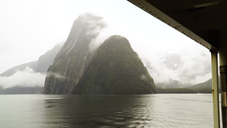 el pico de inglete que se eleva sobre el agua se ve desde el barco en un fiordo en nueva zelanda