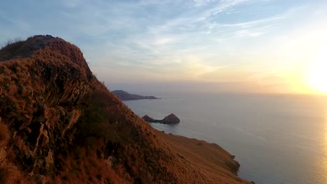 aerial-footage-of-rock-crest-formation-wild-vegetation-in-gili-lawa-darat-island-inside-the-famous-travel-destination-komodo-national-park,-cinematic-sunrise