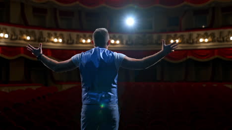 middle age male entertainer, presenter or actor on stage. public speaker gives performance in front of empty auditorium. man in theater.