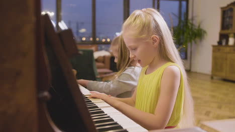 Side-View-Of-Two-Little-Girls-Playing-Old-Piano-At-Home-3