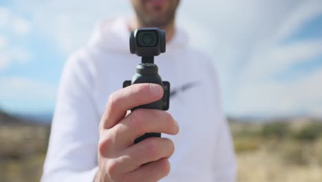 vlogger showing modern dji osmo pocket 3 stabilized intelligent tracking mobile gimbal camera for creative videography