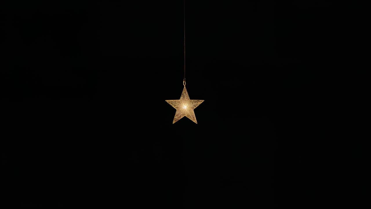 Intern belysning lysner femtakket stjerne på snor på sort baggrund, hvilket skaber halo og linse-flare
