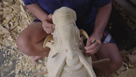 artisan carving in wood barong mask for balinese festivity