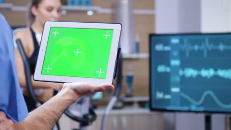 Doctor-in-sport-science-holding-tablet-with-green-screen