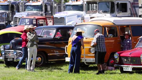 personas que interactúan en una exposición de coches antiguos