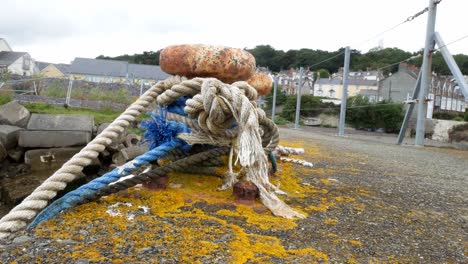 ropes tied to rusty metal mooring on coastal marine fishing harbour shipyard dolly left