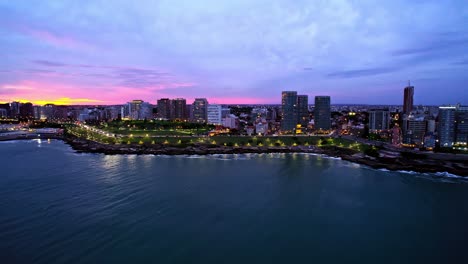 aerial orbit of vibrant sunset over mar del plata and san martin park, argentina