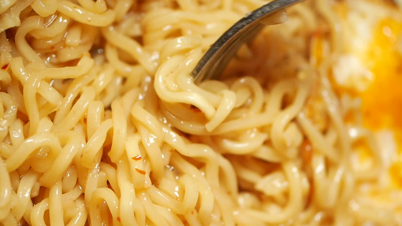 Close-Up of Instant Noodles Being Stirred with a Fork