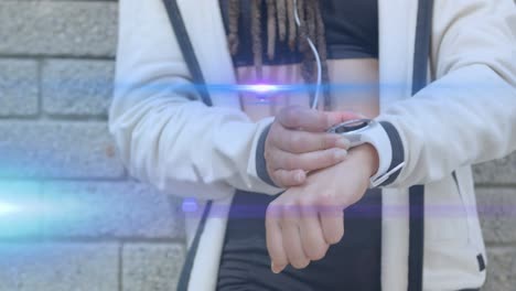 animation of blue light beams over midsection of woman using smartwatch