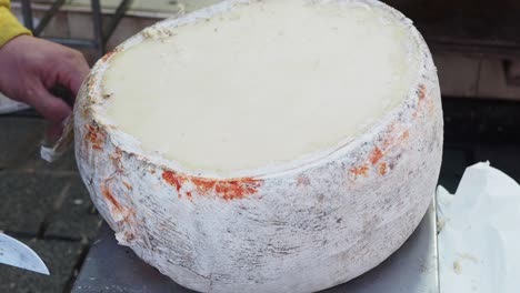 large wheel of cheese at a market