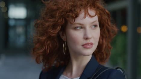 retrato de cerca hermosa joven mujer de negocios gira la cabeza sonriendo confiada viento soplando el cabello lindo cabeza roja mujer cámara lenta belleza femenina