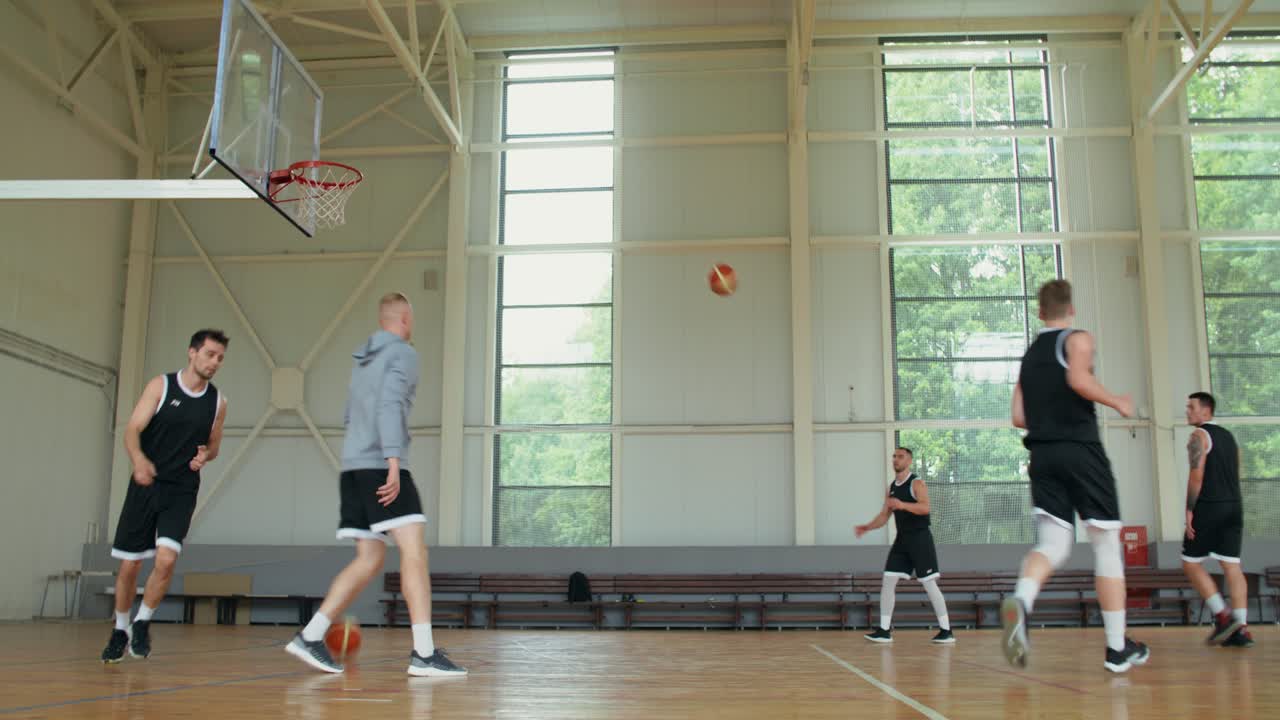 Giocatori di basket che giocano su un campo al coperto