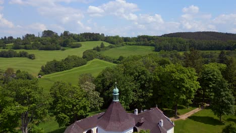 Majestic-aerial-top-view-flight-Round-Chapel-on-mountain-hill,-Krumlov-Czech-Republic-Summer-2023