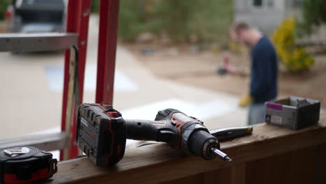 a construction worker grinding metal and making sparks fly on a job site with a drill and tools in the foreground