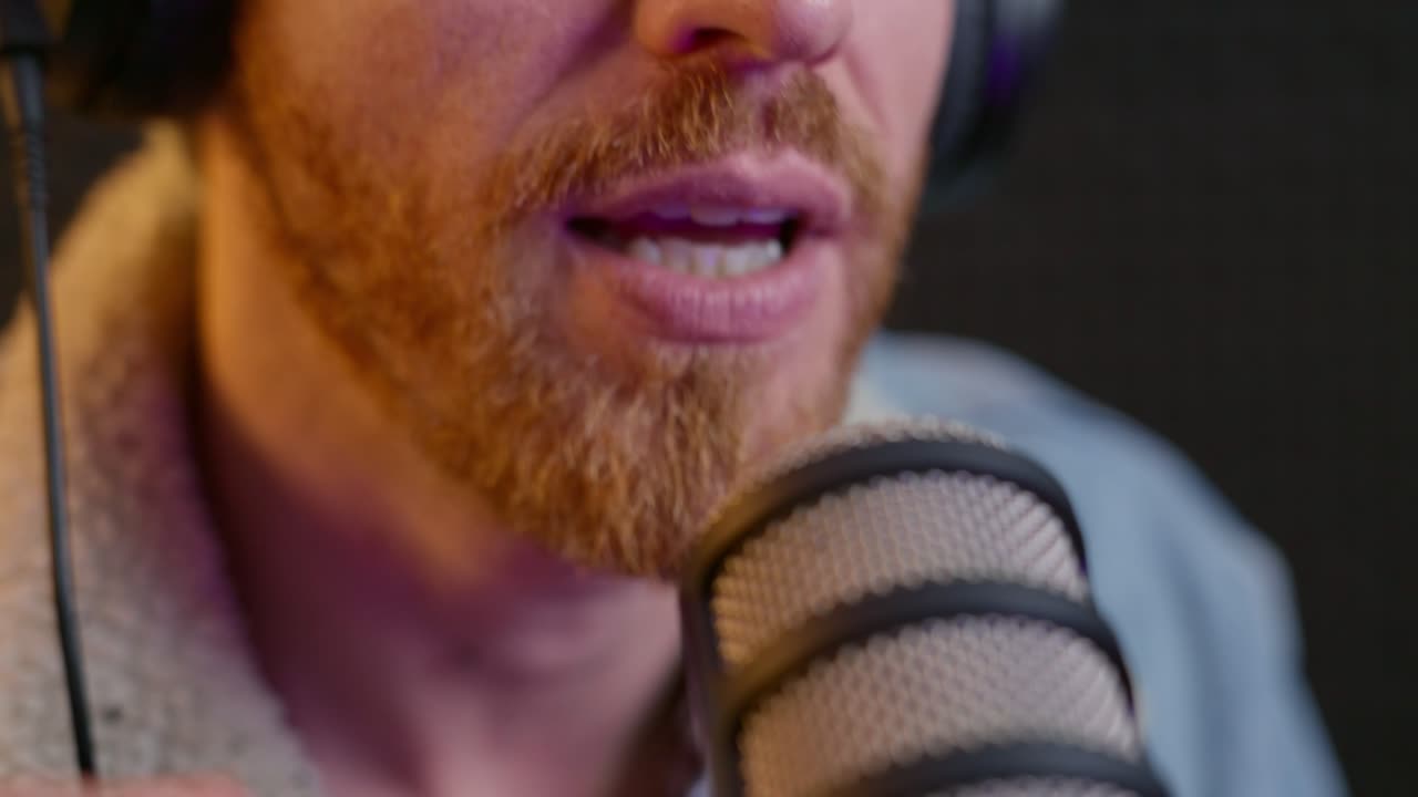 cerca de la boca del hombre mientras habla con el micrófono de radio o podcast en el estudio. anfitrión en un programa de transmisión en vivo hablando con confianza con el mic. influencer usando auriculares dentro de la cabina de grabación profesional
