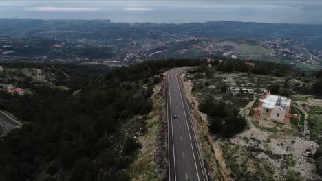 aerial shot following a car on the roads in the mountains