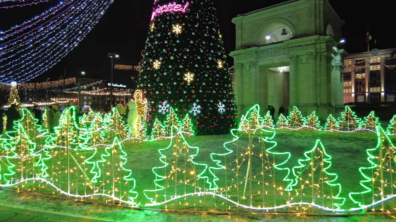Chisinau, Moldova - December 20, 2021: Bright lights and colorful decorations create a festive atmosphere in the park as families gather to enjoy the holiday spirit. Trees and ornaments sparkle under the night sky